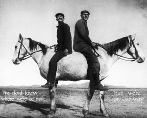 Composite photograph of two men seated on a horse with two heads, ca.1900