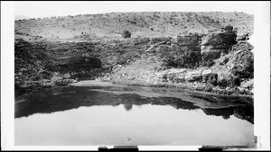Reflection in water of Montezuma's Well, near Indian cliff dwellings in Verde Valley, Arizona, ca.1900