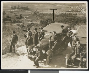 Man gathered around an early automobile