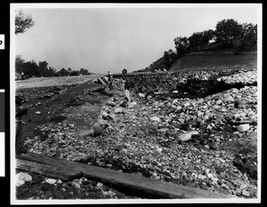 Men investigating a pit left by flood damage, 1938