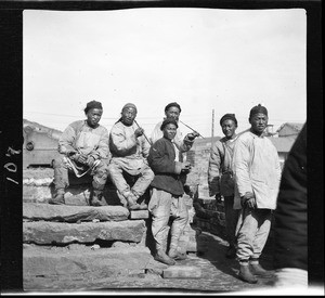 "Coolie" laborers smoking and resting on a rooftop in China, ca.1900