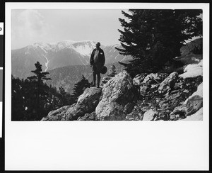 Will Thrall standing on a rock by the edge of a mountain, ca.1930