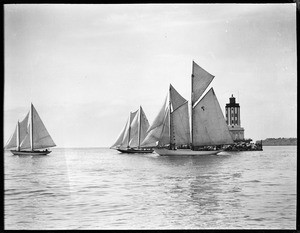 Three yachts sailing near the lighthouse in Los Angeles Harbor