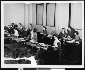 Interior view of employees at work in an office, ca.1950