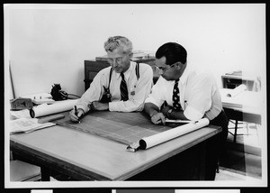 Interior view of Department of Public Works, showing two men at a desk in the Hollywood office