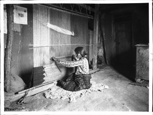 Navajo Indian woman blanket maker weaving a blanket at a loom, ca.1901