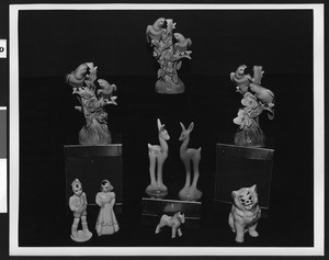 Close-up of a display of figurines, showing animal figurines as well as human. ca.1950