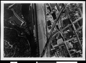 Aerial view of the swollen Los Angeles River showing the old Los Angeles Jail and Midway railroad yard, Los Angeles, 1938