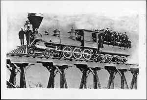 Conness Number Six engine with fuel box, standing on a trestle, Central Pacific Railroad, March, 1865