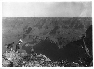 Woman and two dogs on the rim of the Grand Canyon, ca.1900-1930