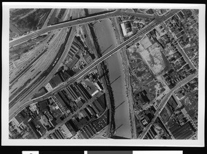 Aerial view of the swollen Los Angeles River showing Souther Pacific Railroad's Bullring Yard, North Broadway and North Spring Streets, Los Angeles, 1938