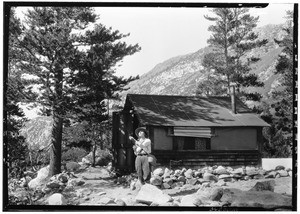 Woman outside a mountain cabin