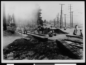 Construction work near railroad track, showing men with cameras