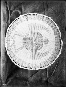 Hopi Indian basket displayed against a cloth backdrop, ca.1900