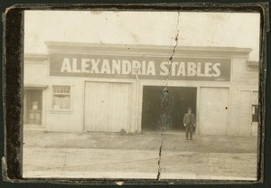 Exterior view of Alexandria Stables, with William E. Christie standing in front, 1902