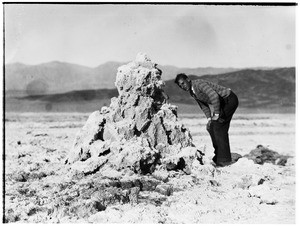 Man standing next to a pile of rock