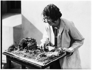 Woman working on a display of Native American life at the Pacific Southwest Museum