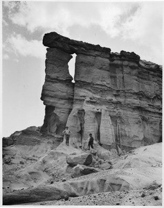 View of Red Rock Canyon showing a rock formation and two travelers, Death Valley, California, ca.1900/1950