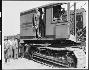 Construction site with officials inside a backhoe, ca.1935