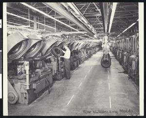 Factory worker using tire vulcanizing molds, ca.1930