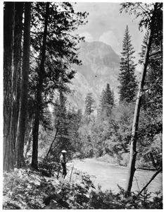 Man standing by a stream in Kings River Canyon, 1900-1950