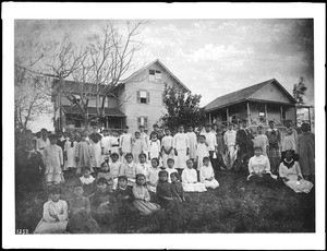 A group of children gather in front of a native Hawaiian school for girls, ca.1890