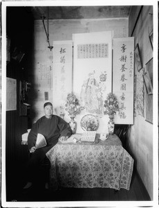 Chinese merchant, Ark Tong, sitting at table with his ancestral chart prepared to received visitors on New Year's, ca.1930