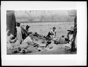 Two women make tortillas in prepration for the family meal, Mexico, ca.1905
