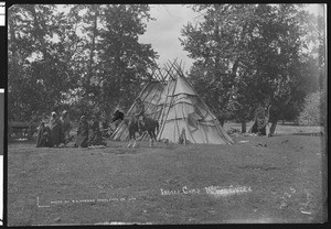 Indian camp with women and children in blankets and a horseback rider, McKay Creek, ca.1900