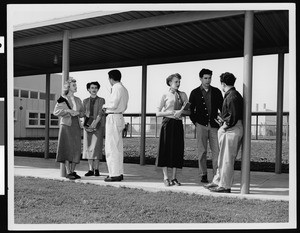 Six students talking outside an unidentified high school, 1950-1959
