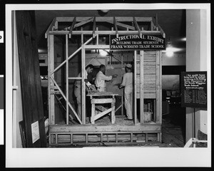 Instructional exhibit by Frank Wiggins Trade School, showing students and teacher, ca.1920-1929