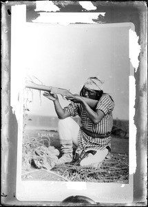 Portrait of an Apache Indian warrior aiming a gun, ca.1884