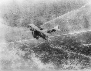 Downward view of a "Chateau Thierre Aeroplane", a World War I aircraft, in flight over Argone Forest and French trenches, ca.1914-1918