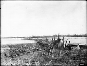 Long curving jetty formed from piles on the Colorado River, New Heading, ca.1900-1950