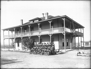 Group of Yuma Indian girls posing in front of their dormitory at the Indian School at Yuma, ca.1900