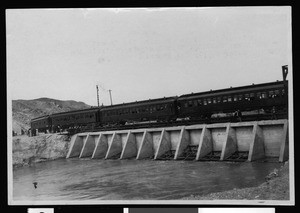 Excursion train crossing cement head gate lower heading in Imperial Valley, ca.1910