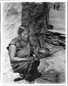 Hopi Indian woman starting to make a basket, ca.1901