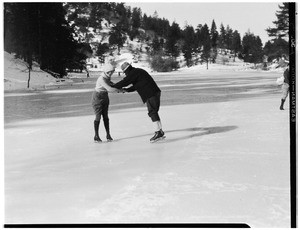 Man and woman holding hands and skating on a rink at Big Pines, ca.1928