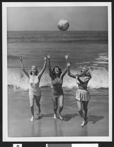 Women tossing a ball in the air at a Los Angeles area beach, ca.1940