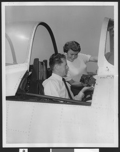 Man and woman in the cockpit of a North American T-2813 Trainer plane, September 1953