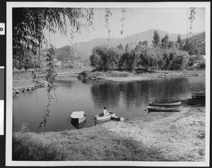Man sitting in a rowboat in a small lake, ca.1940