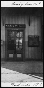 Exterior view of the East Side Railroad Station, showing a Wells Fargo and Company Express sign, 1917