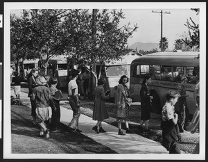 Students boarding a line of Los Angeles City School District buses, ca.1940