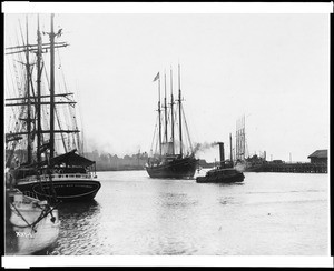 View of the Los Angeles Harbor, showing the schooner "Meteor" being towed by a tugboat, ca.1900/1909