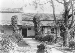 Exterior view of the Mission San Juan Bautista, showing the garden entrance, ca.1900