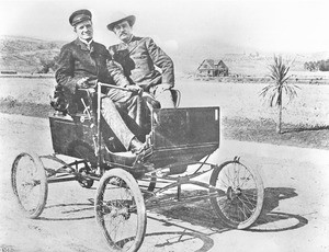 General Sherman sitting at the wheel of a Mobile Stanhope Steamer with William A. Hammell sitting as a passenger, Hollywood Boulevard, 1900