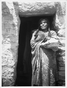 Hopi Indian woman holding a stone for house construction in the village of Oraibi, ca.1901