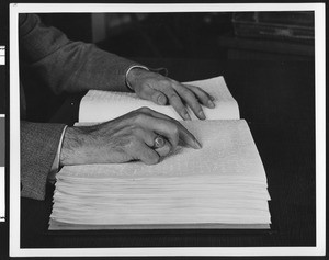 Hands "reading" a Braille book, ca.1928