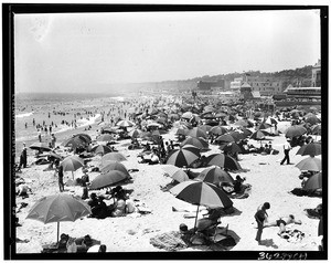 Beachgoers under umbrellas on the sand near Santa Monica