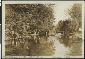 Three people canoeing on the Mill Race in Eugene, Oregon